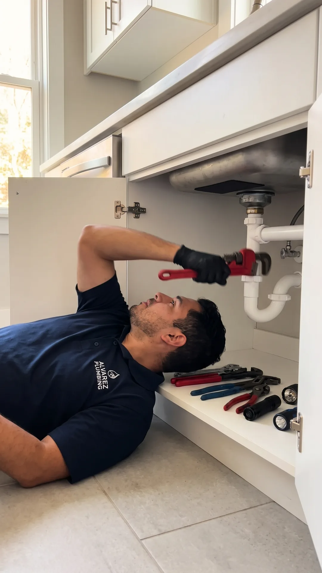 A plumber filming a repair on a phone, the still frame from a vertical in-feed video ad.